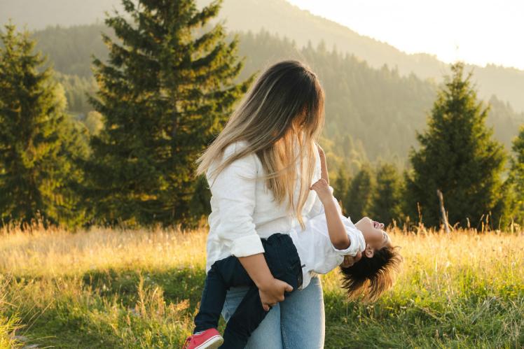 woman and boy front of a bright landscape