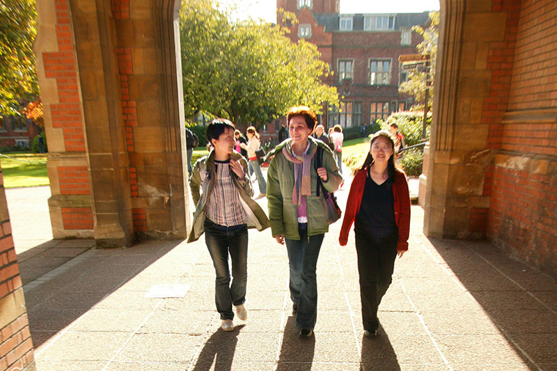 Students walking through archway in quad